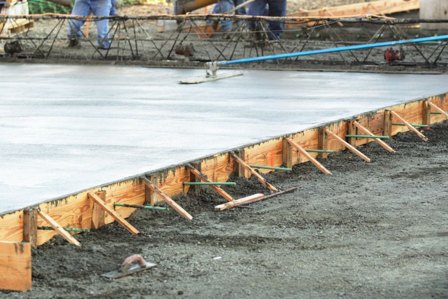 Concrete foundation slab with wooden formwork and steel reinforcement at a construction site